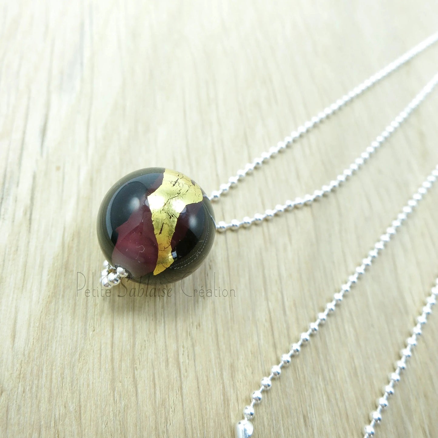 Collier Artisanal long, Perle Bordeaux ornée d'une feuille d'Or - Petite Sablaise