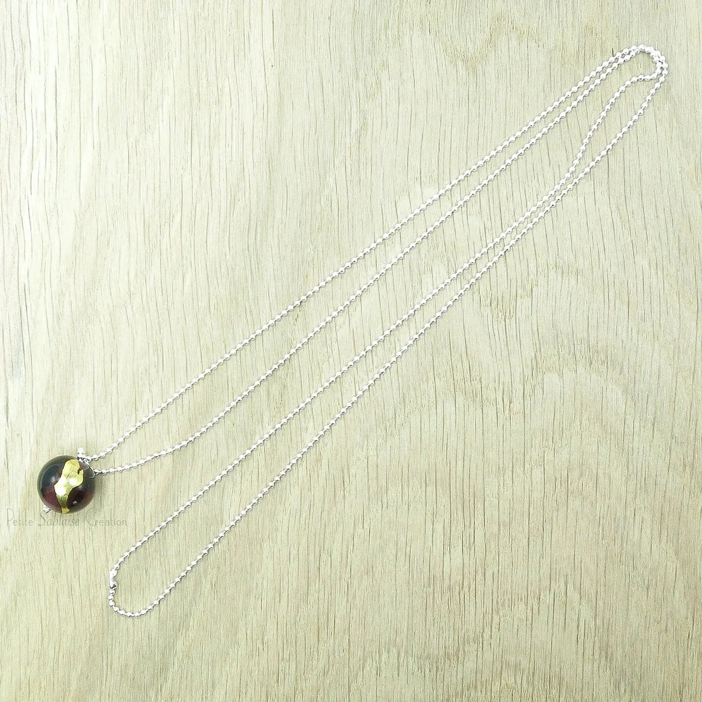 Collier Artisanal long, Perle Bordeaux ornée d'une feuille d'Or - Petite Sablaise