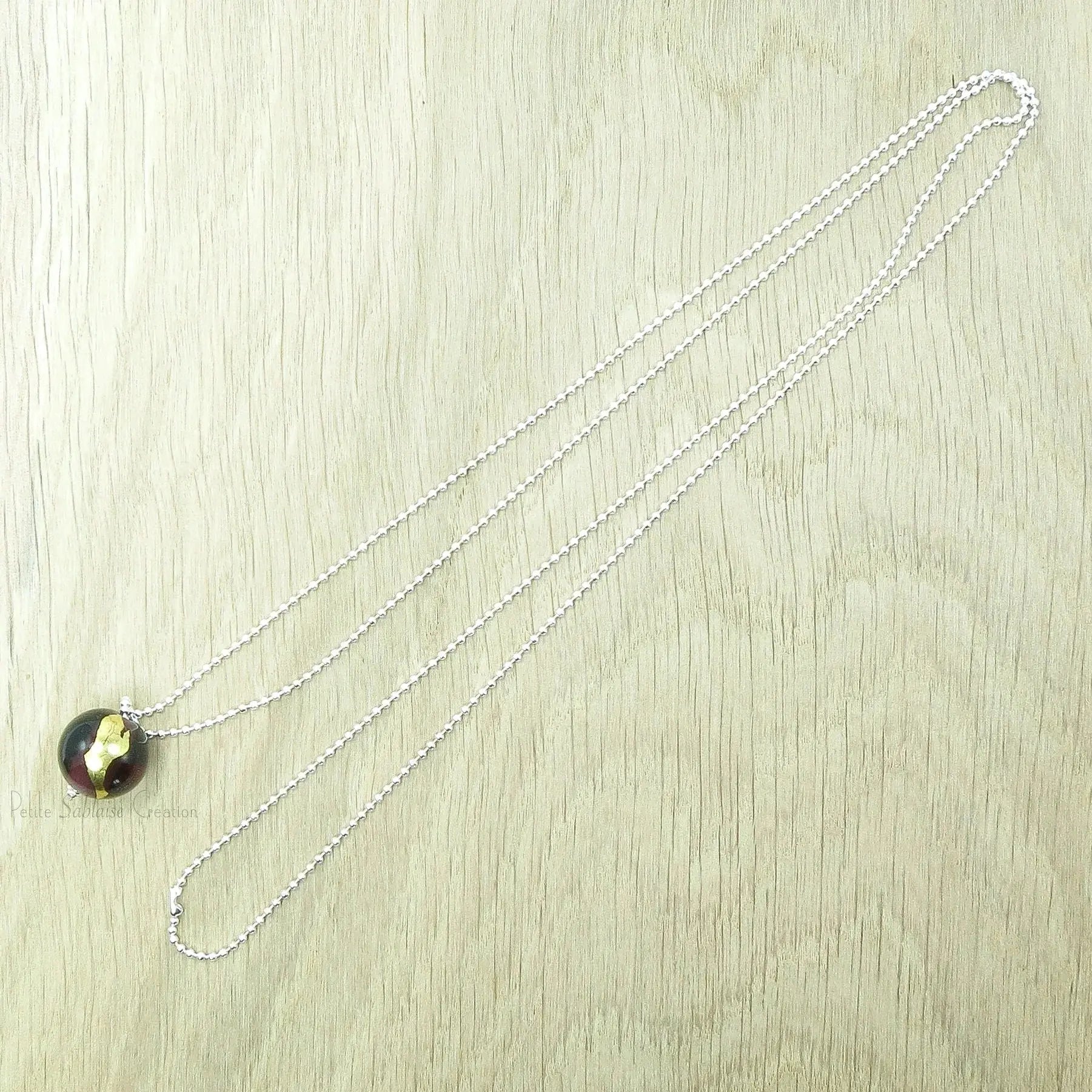 Collier Artisanal long, Perle Bordeaux ornée d'une feuille d'Or - Petite Sablaise